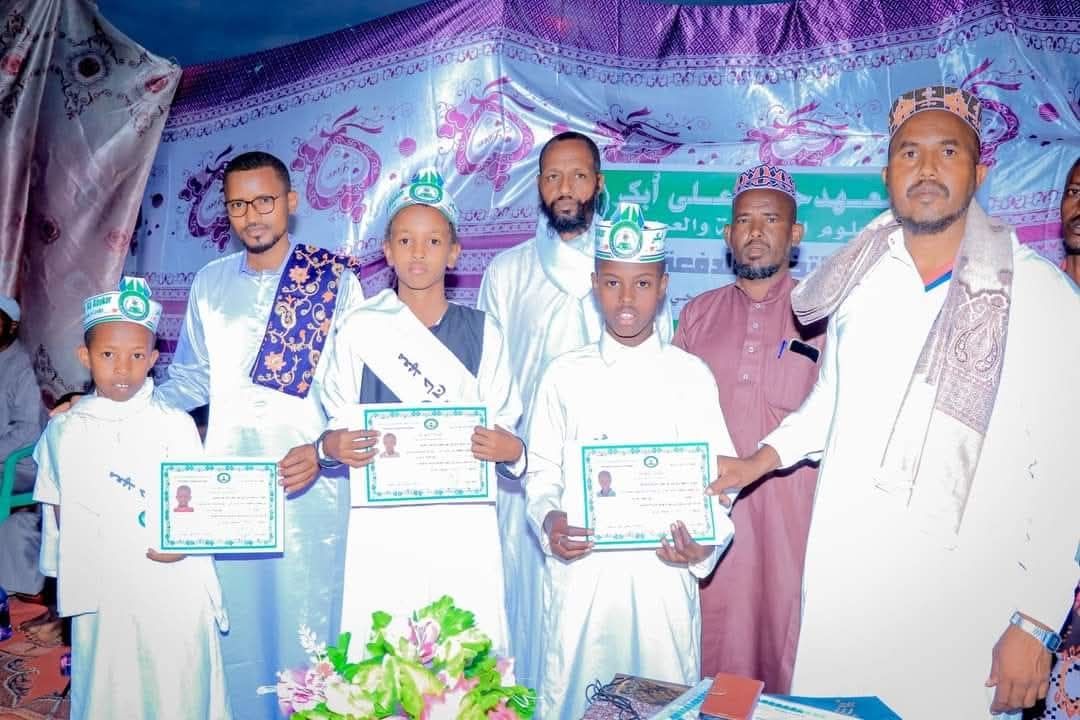 طلاب المعهد يحملون شهادات التخرج مع معلميهم